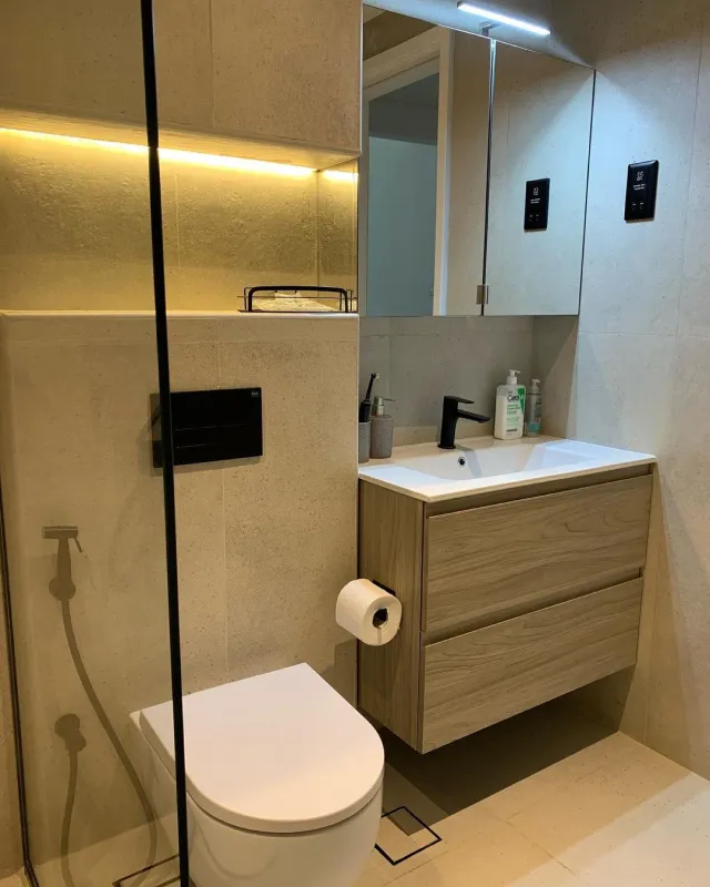 Modern bathroom renovation in Dubai featuring a walk-in shower, floating vanity and warm natural finishes